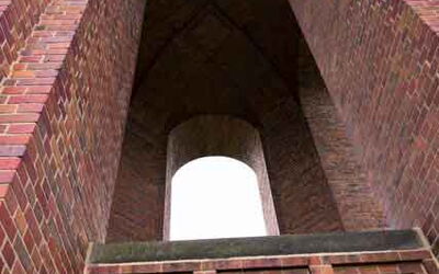 Ein gemauerter Turm. Durch ein Fenster fällt Licht.