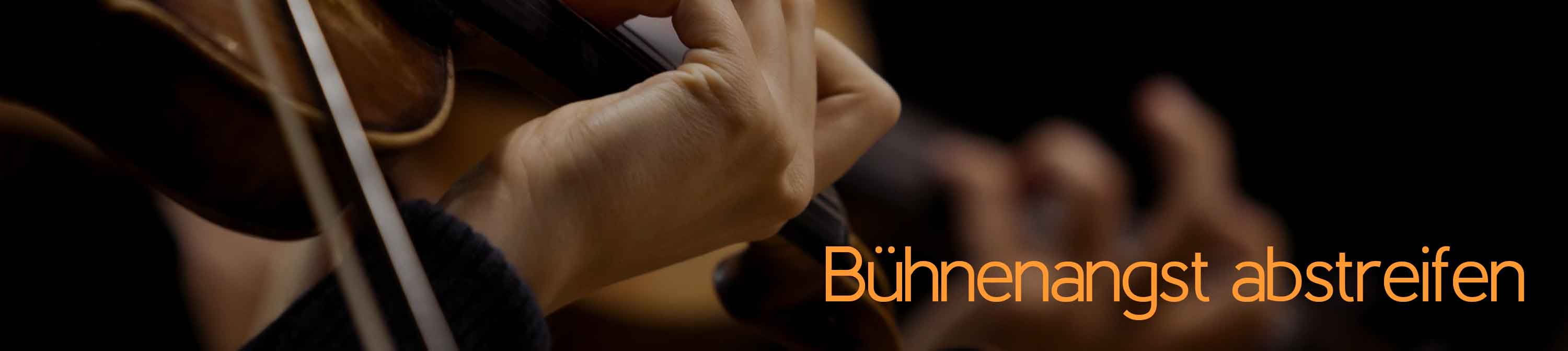 Bühnenangst, Lampenfieber und Auftrittsangst abstreifen. Eine Hand spielt auf einer Violine. Eine weitere Hand, die auf einer Geige spielt, ist im Hintergrund zu sehen. Bühnen- oder Auftrittsangst ist mehr als Lampenfieber und sollte behandelt werden.