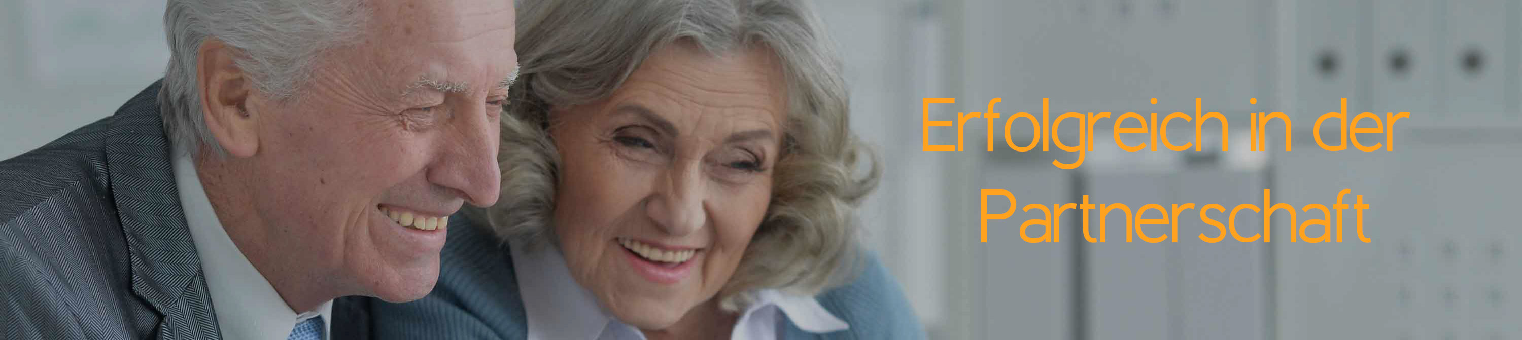 Ein älterer Mann und eine ältere Frau schauen gemeinsam auf ein Notebook. Sie sehen glücklich aus, da sie gemeinsam etwas gelöst haben. Erfolgreich in der Partnerschaft.